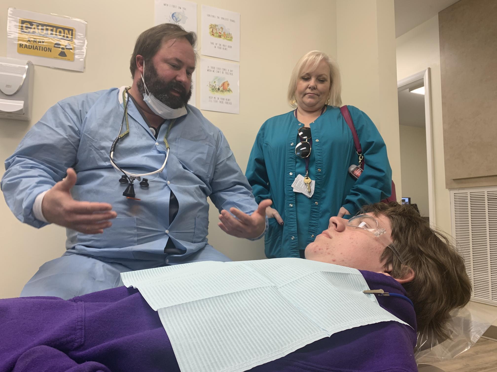 dentist and hygienist speaking to child patient